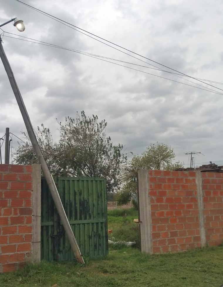 Calle Unanue 25, un poste quebrado sostiene cables con energía.